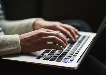 Hands typing on a keyboard